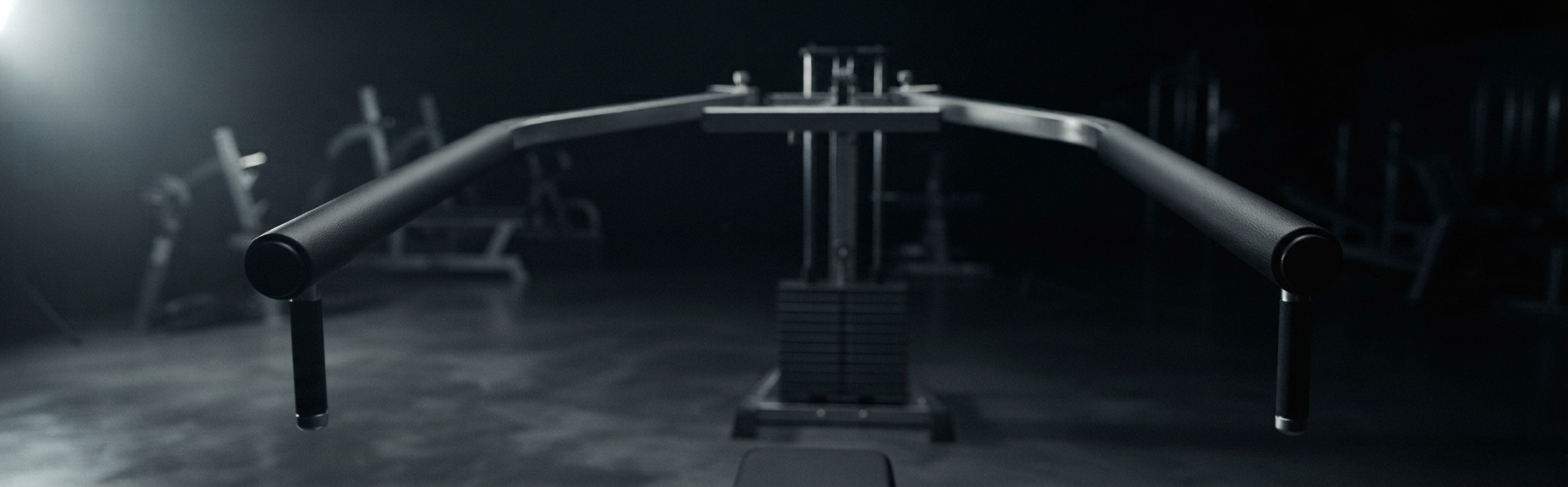 A reverse pec deck machine in a darkened gym, arms swept forward